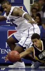 Chris Massie and UNCG forward Ronnie Burrell struggle for a loose ball during the second half.