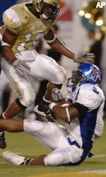 Memphis running back Joseph Doss, right, breaks the tackles of UCF's Jason Venson, left, and Joe Burnett and scores a touchdown during the second quarter. (AP Photo/Phelan M. Ebenhack)