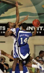 Chris Douglas-Roberts challenges Kentucky's Joe Crawford in the first half. (AP Photo/Michael Conroy)
