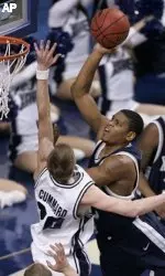 Justin Cage takes a shot over BYU's Lee Cummard. Cage finished with eight points. (AP Photo/James Crisp)
