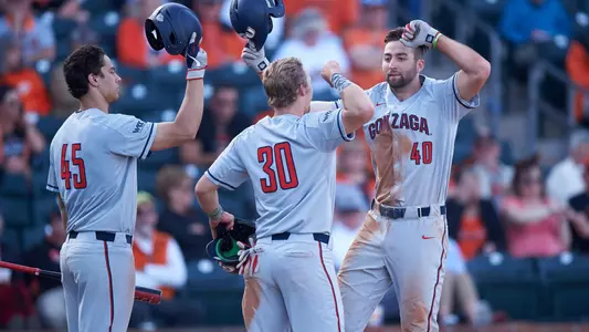 Ryan Sullivan, Brett Harris, and Gabriel Hughes celebrate Sullivan's homer