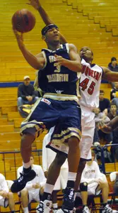 George Washington's Mike Hall looks to pass under the hoop against Duquesne's DeVario Hudson, right, during the first half. (AP Photo/John Heller)
