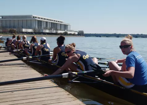 GW women's rowers push away from the dock in the shadow of the Kennedy Center.