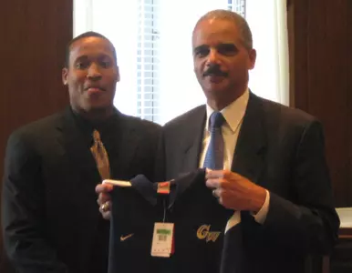 U.S. Attorney General Eric Holder displays a GW polo shirt presented to him by junior Travis King and the GW men's basketball team on Monday.