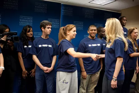 GW women's lacrosse senior Emily Perling shakes hands with Chelsea Clinton at Tuesday's GW + Phones = Hope Kickoff Rally. Student-athletes donated and can continue to donate toward GW's goal of 20,000 used cell phones by the start of CGI U in March.