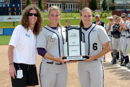 Senior captains Kara Clauss and Lauren Wilson accept the Atlantic 10 runner-up trophy.