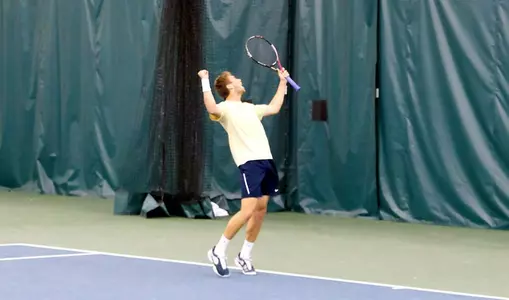 Senior Nikita Fomin celebrates after clinching the A-10 Championship title for GW at No. 2 singles.