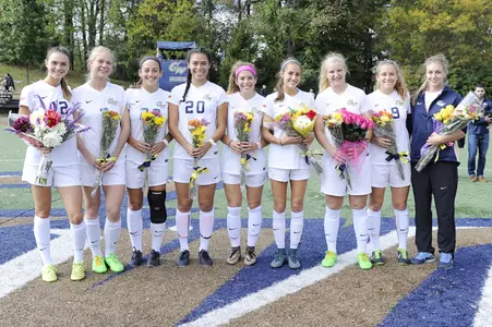 Women's Soccer Holding Flowers at midfield