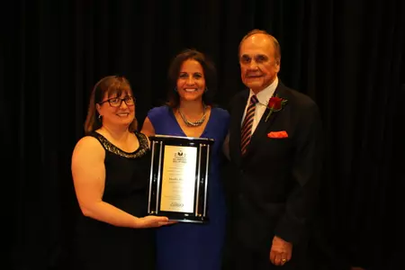 Head coach Jennifer Rizzotti with CoSIDA president Judy Wilson and legendary broadcaster Dick Enberg.