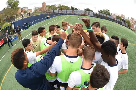 Men's soccer huddles on the field
