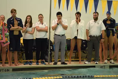 Swimming & Diving looks on at a meet