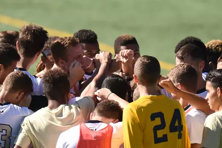 Men's soccer huddles