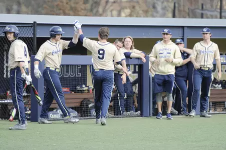Baseball high fives in front of the Dugout