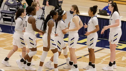 Women's basketball celebrates a win over Delaware