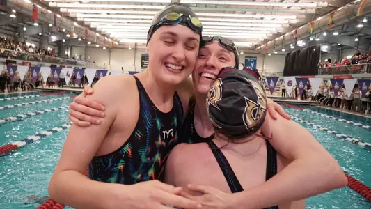 GW women's swimmers celebrate a win at the A-10 Championships in 2019