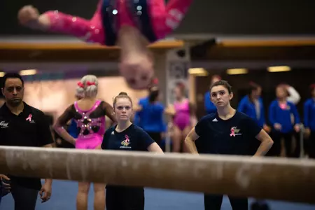 GW Student Gymnastics Managers watch Colonials compete on beam.