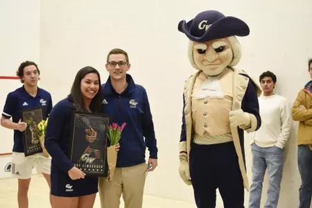 Engy Elmandouh and Head Coach Anderson Good posing with George during senior game celebration.