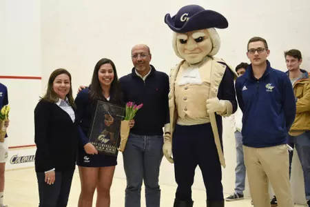 Engy Elmandouh and family posing with George and Head Coach Anderson Good during senior game celebration.