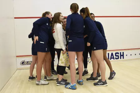 GW women's squash team huddle during senior game.