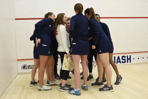GW women's squash team huddle during senior game.