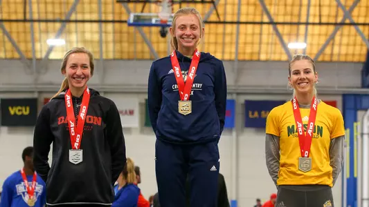 Suzanne Dannheim stands atop the podium after winning a conference championship.