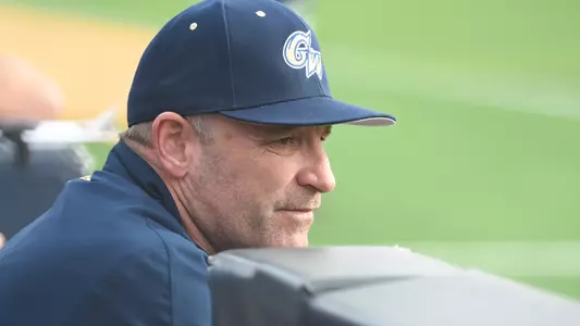 GW baseball head coach Gregg Ritchie looks out to the field from the dugout.