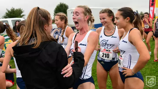 GW women's cross country celebrates its 2021 A-10 title.