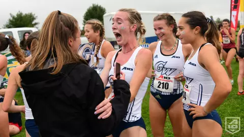 GW women's cross country celebrates its 2021 A-10 title.