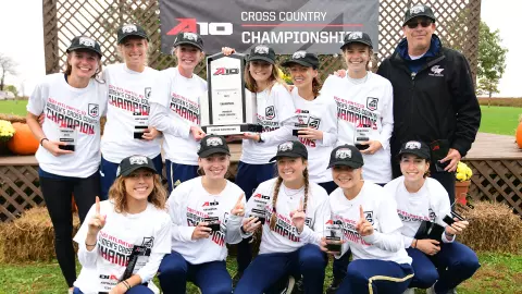 GW women's cross country celebrates its 2021 A-10 title.