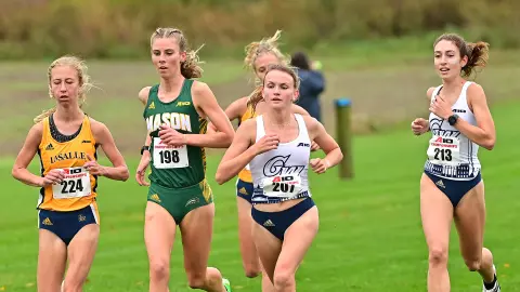 Margaret Coogan and Peri Pavicic run at the 2021 A-10 Cross Country Championships.