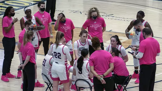 Women's basketball huddles during a break in the action