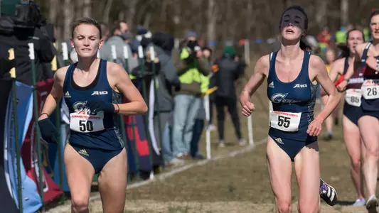 Margaret Coogan and Kathryn Nohilly cross the finish line at the A-10 Championship