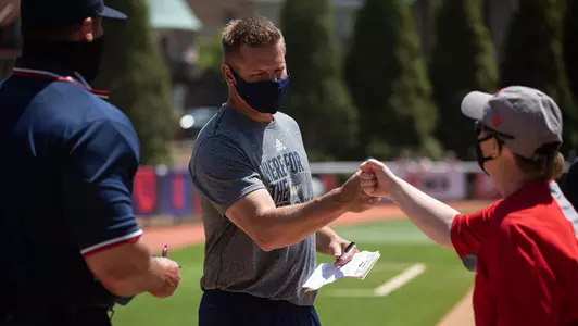 Shane Winkler greets Dayton's Cara LaPlaca at home plate before the 2021 A-10 Championship final.