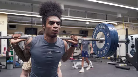 James Bishop squats during a summer weightlifting session.
