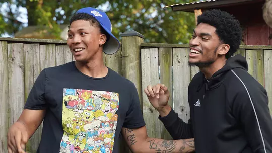 Ira Lee and Ricky Lindo Jr. share a laugh during a summer BBQ at Head Coach Jamion Christian's house.
