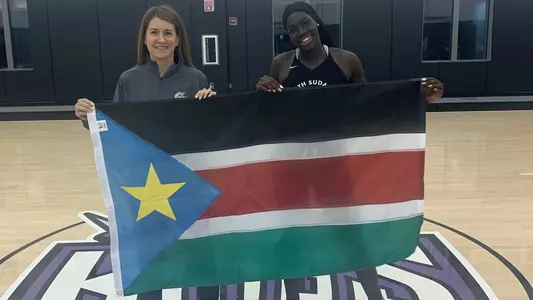 Nya Lok and Coach McCombs hold the South Sudanese flag at the team's training camp