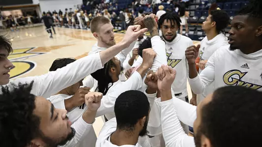 Men's basketball huddles prior to a game at the Smith Center