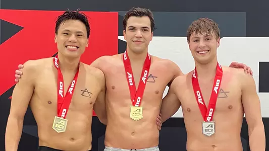 Dylan Koo, Durde Matic and Ethan Tulenko pose with their 100 fly medals at the A-10 Championships.
