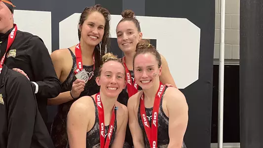 Barbara Schaal, Ava DeAngelis, Marlee Rickert & Julia Knox pose with their 400 medley relay medals at the A-10 Championships.