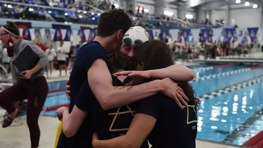 Members of GW swimming and diving hug at the A-10 Championships.