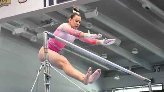 Anneliese Silverman competes on bars at Pink Meet