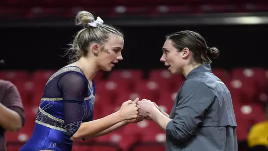 Steph Stoicovy Worrell and Payton Lynch fist bump before Payton's floor routine