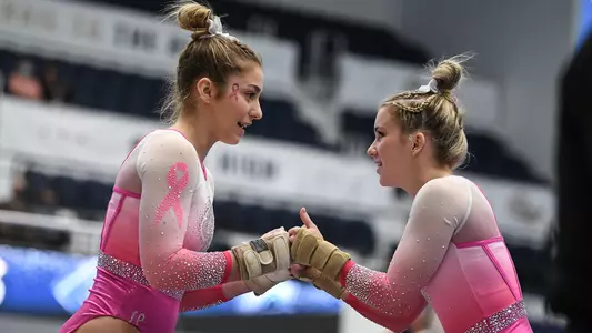 Marlee York and Kendall Whitman fist bump before floor routine