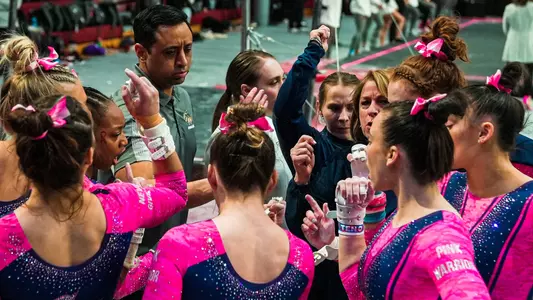 Gymnastics huddles at Temple quad meet