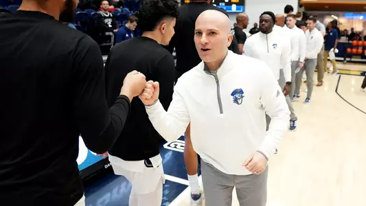 Chris Caputo fist bumps his team prior to a game vs. La Salle
