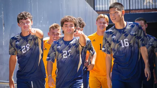 Ben Hissrich, Dan Dobrin and Alex Chung walking out of the tunnel at the GW Soccer Field