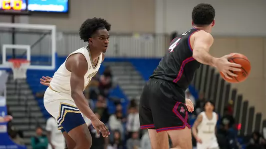 Darren Buchanan Jr. guards the ball at American