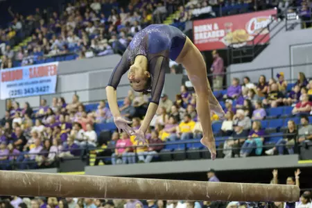 Gymnast flips on beam