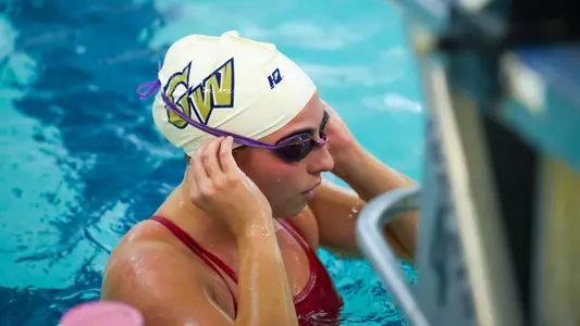 Women's swimming and diving preparing to swim at a recent practice