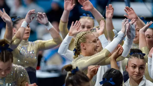 Delaney DeHaan Celebrates a successful bar routine at UNC